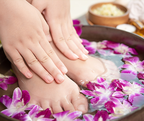 Closeup of freshly painted toenails resting on white pedicure towel