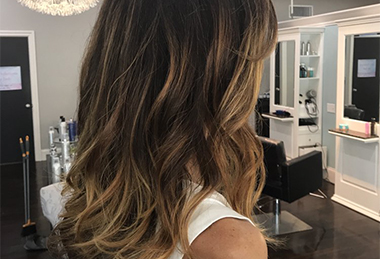 Stylist wrapping client’s hair in foil for highlighting at main salon page