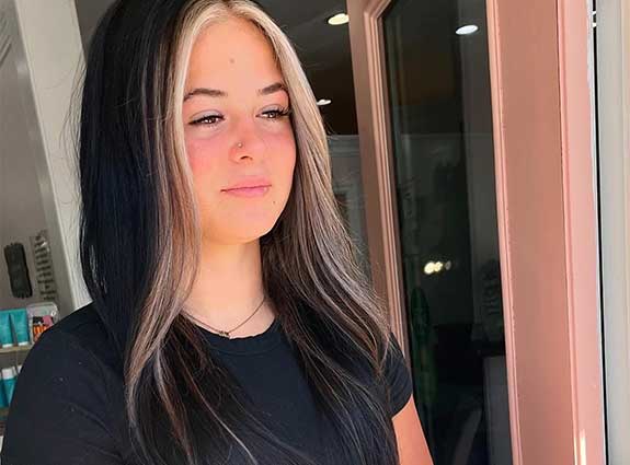 Client with styled waves sitting in chair while stylist adjusts finished look