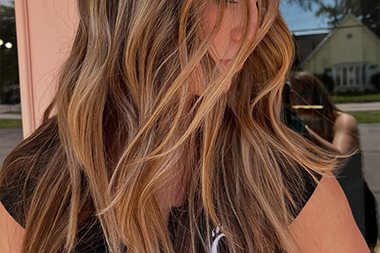 Hairstylist consulting with client while pointing to style options on tablet