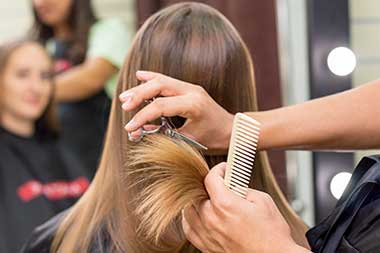 Cozy salon waiting area with chairs, side table, and decorative plants