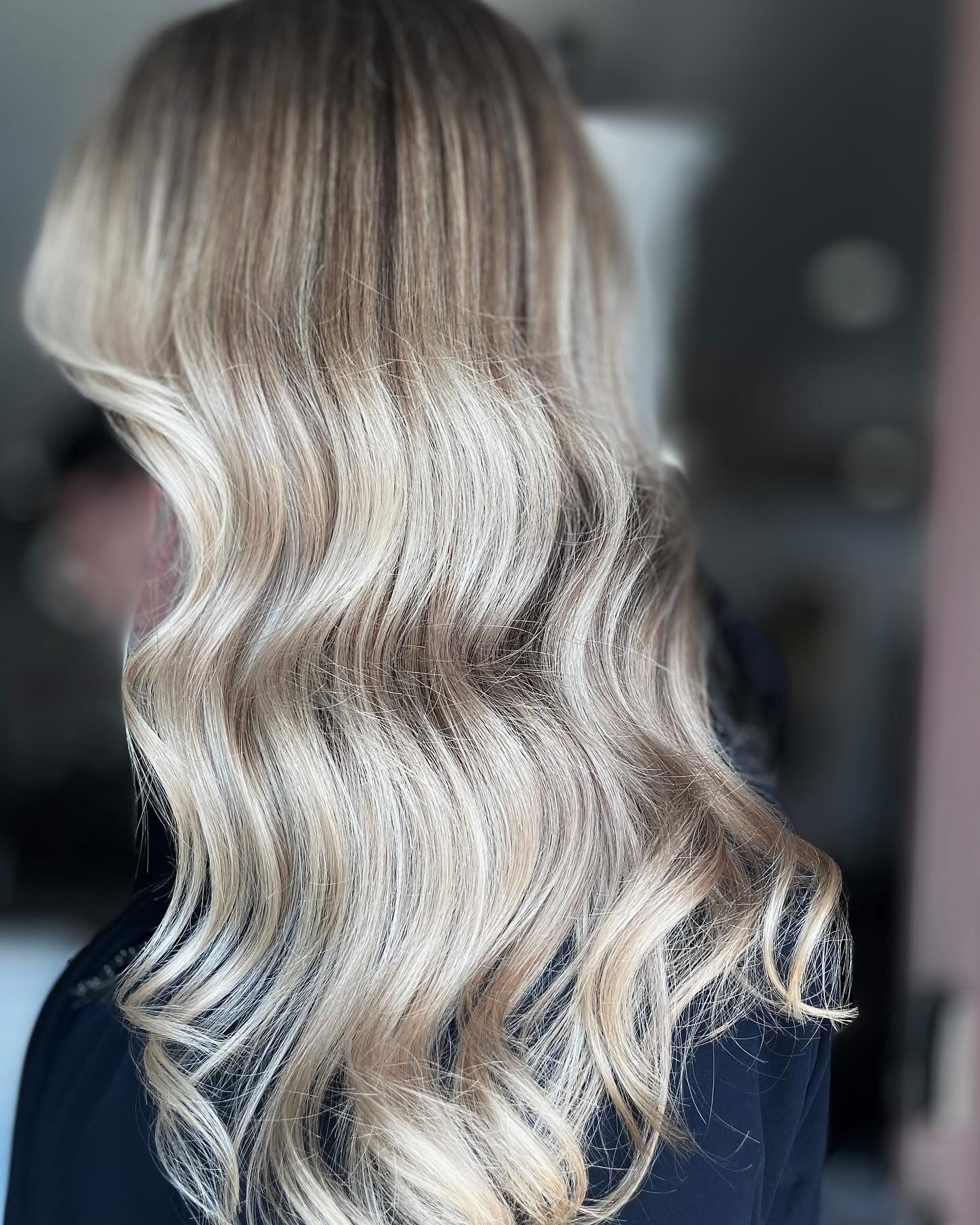 Salon team standing together inside reception area near product display shelves